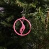 Close-up of a Pink Glow in the Dark Pole Dance Ornament on a decorated Christmas tree branch. Amira Perun Xmas Decor
